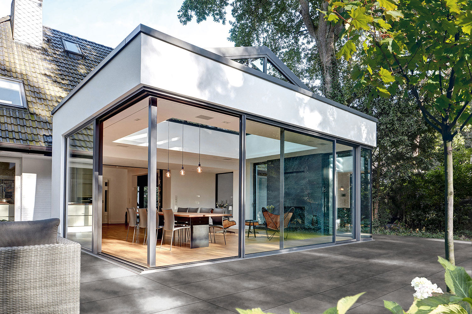 100x50 CreativeLine-Terrassenplatten in grauer Natursteinoptik von Woehe & Heydemann verlegt auf einer modernen Terrasse am Wintergarten
