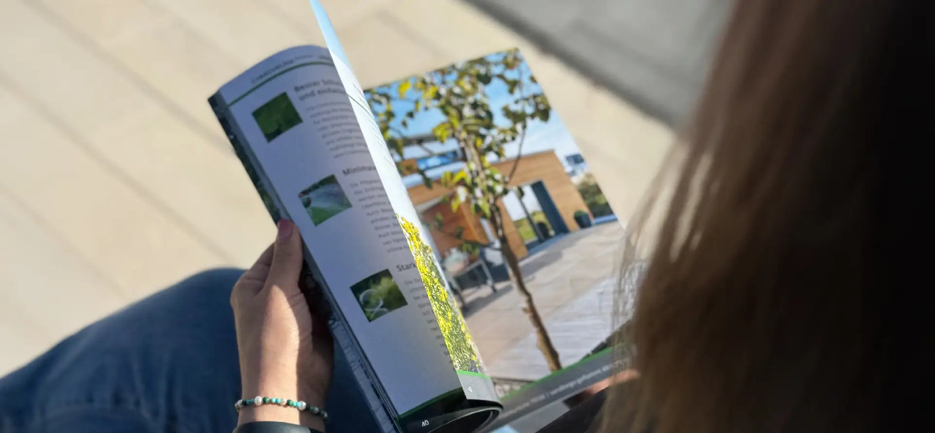 Person blättert durch den Terassenplatten-Katalog von Woehe & Heydemann