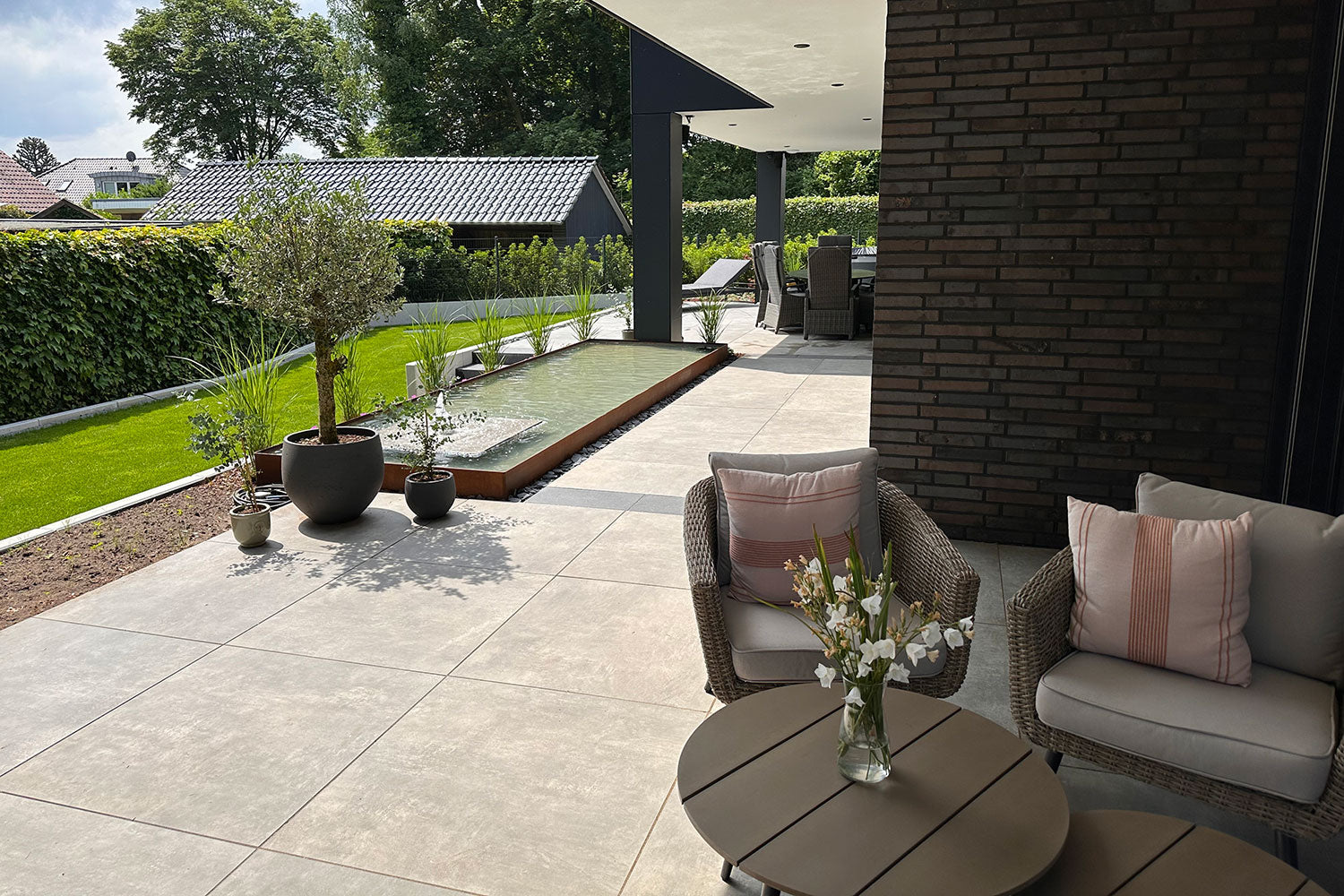 80x80 CeramicLine³-Terrassenplatten in beiger Natursteinoptik von Woehe & Heydemann verlegt auf einer modernen Terrasse 