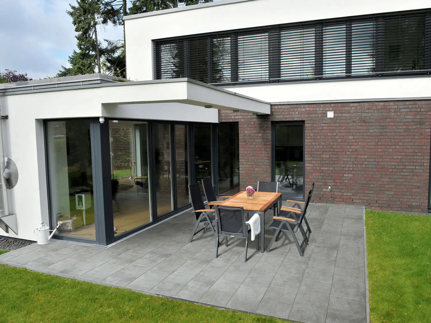 80x40 CeramicLine³-Terrassenplatten in grauer Betonoptik von Woehe & Heydemann verlegt auf einer modernen Terrasse 