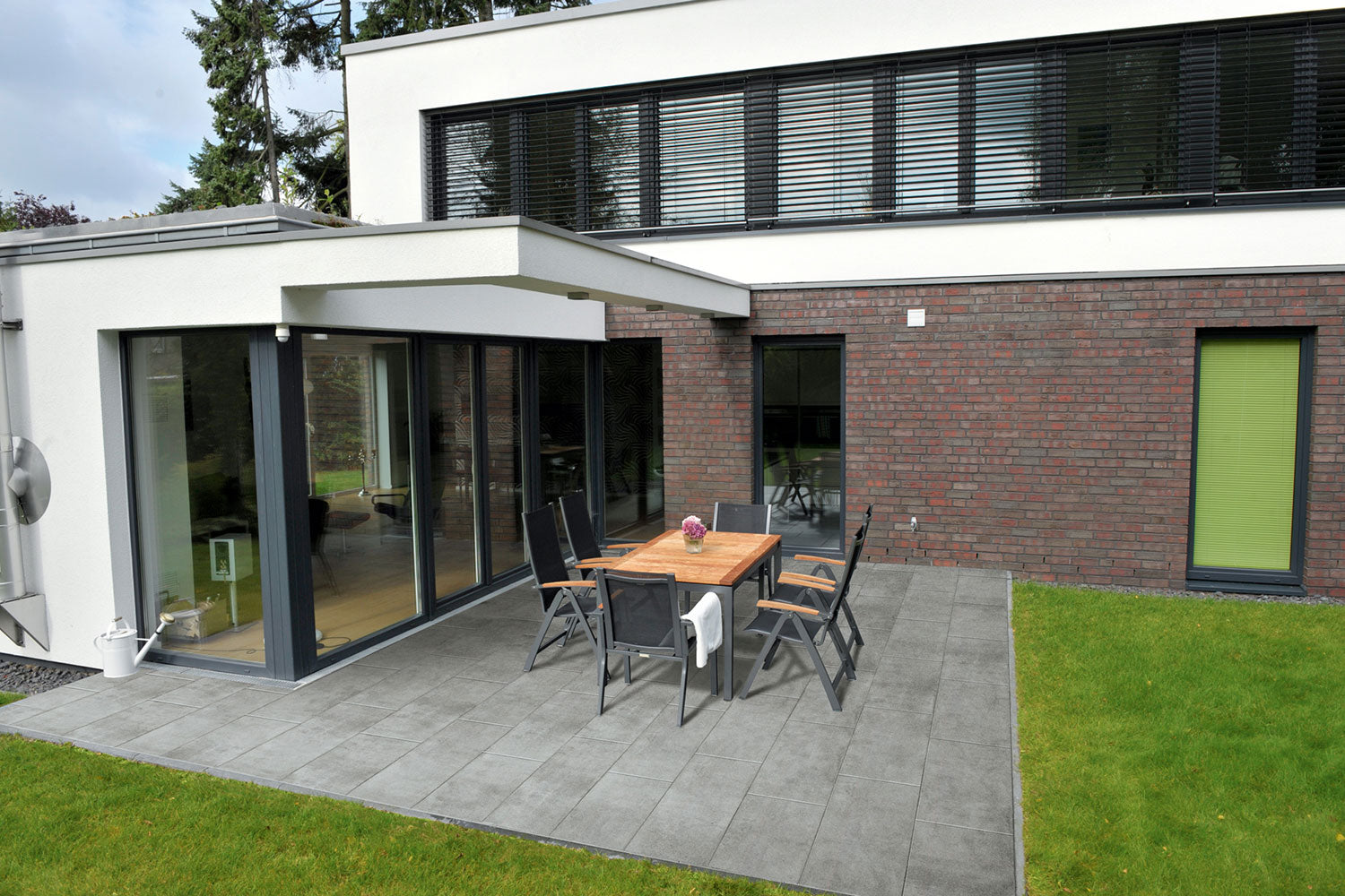 80x40 CeramicLine³-Terrassenplatten in grauer Betonoptik von Woehe & Heydemann verlegt auf einer modernen Terrasse 