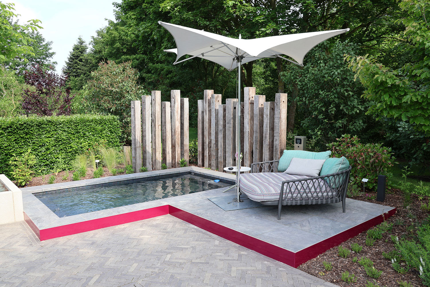 60x60 CeramicLine³-Terrassenplatten in beiger Natursteinoptik von Woehe & Heydemann verlegt auf einer modernen Terrasse mit Pool und Liegestuhl