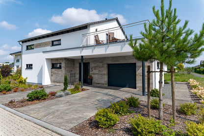 90x90 CeramicLine³-Terrassenplatten in beiger Natursteinoptik von Woehe & Heydemann verlegt auf einer modernen Einfahrt