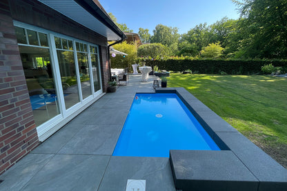 80x80 CeramicLine³ -Terrassenplatten in grauer Natursteinoptik von Woehe & Heydemann verlegt auf einer modernen Terrasse mit Pool