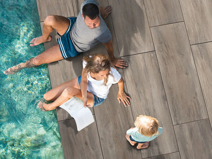 120x40 CeramicLine³ -Terrassenplatten in brauner Natursteinoptik von Woehe & Heydemann verlegt auf einer modernen Terrasse am Pool