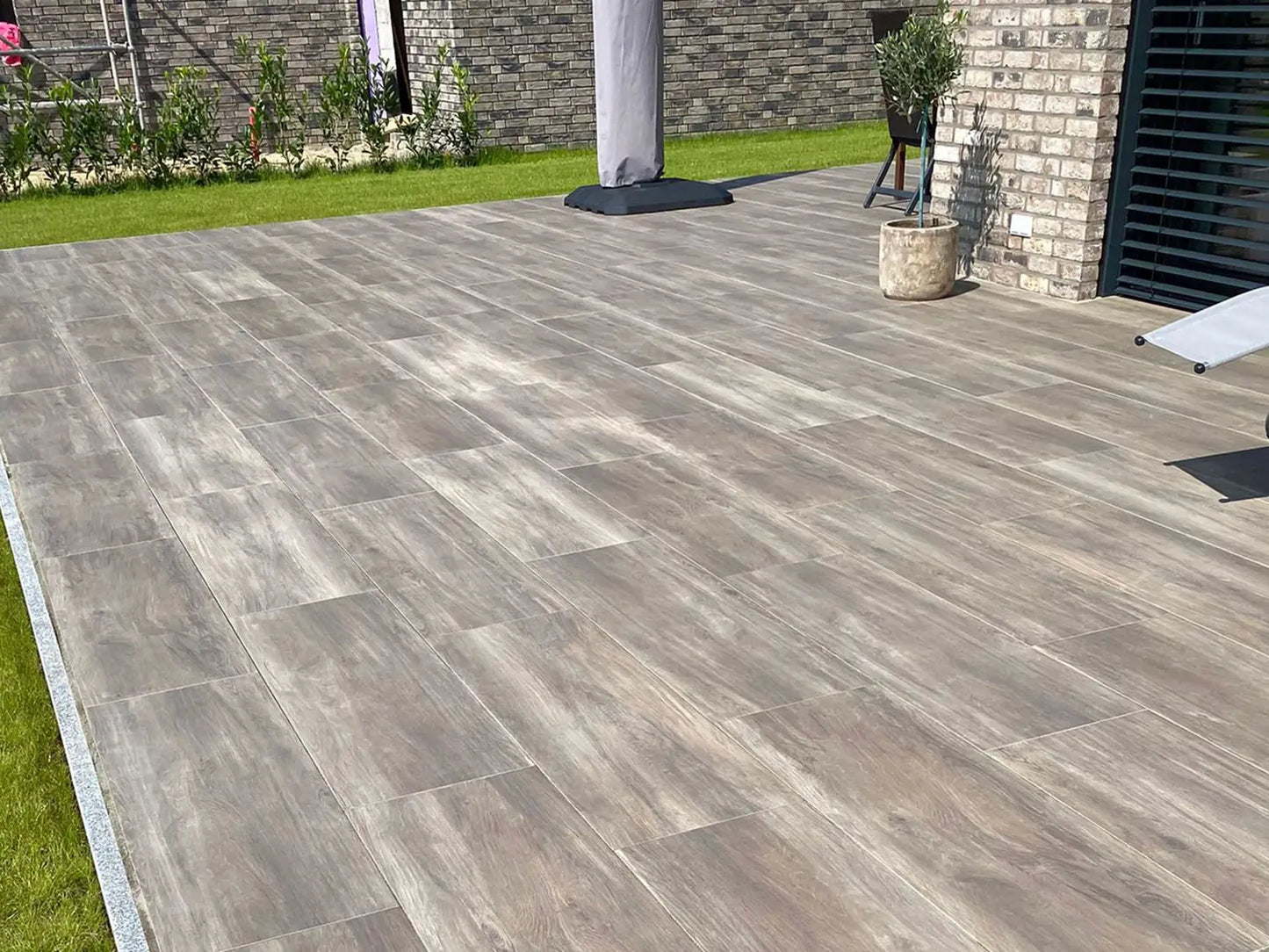 120x40 CeramicLine³ -Terrassenplatten in brauner Holzoptik von Woehe & Heydemann verlegt auf einer modernen Terrasse 