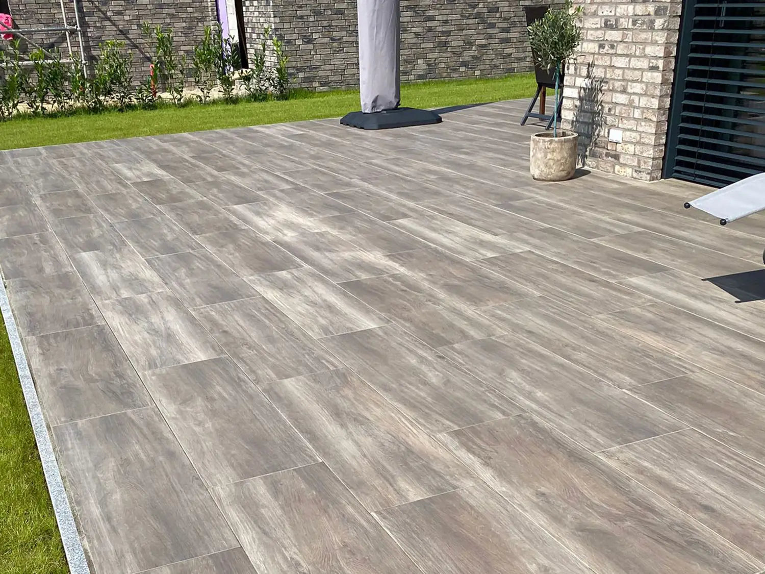 120x40 CeramicLine³ -Terrassenplatten in brauner Holzoptik von Woehe & Heydemann verlegt auf einer modernen Terrasse 