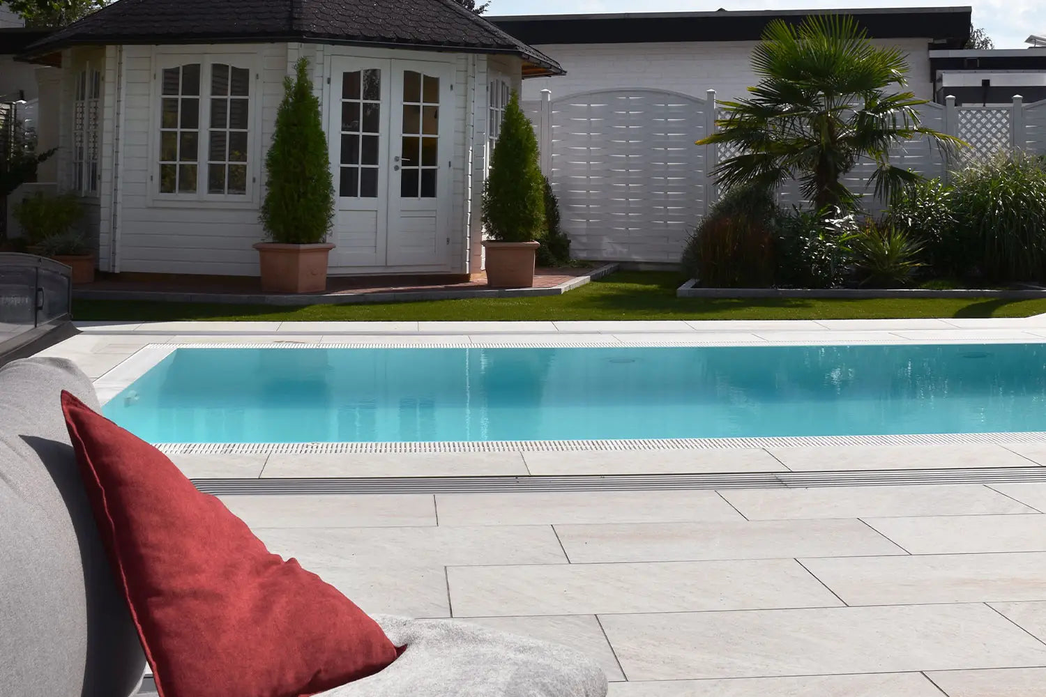 100x50 CeramicLine²-Terrassenplatten in beiger Natursteinoptik von Woehe & Heydemann verlegt auf einer modernen Terrasse mit Pool