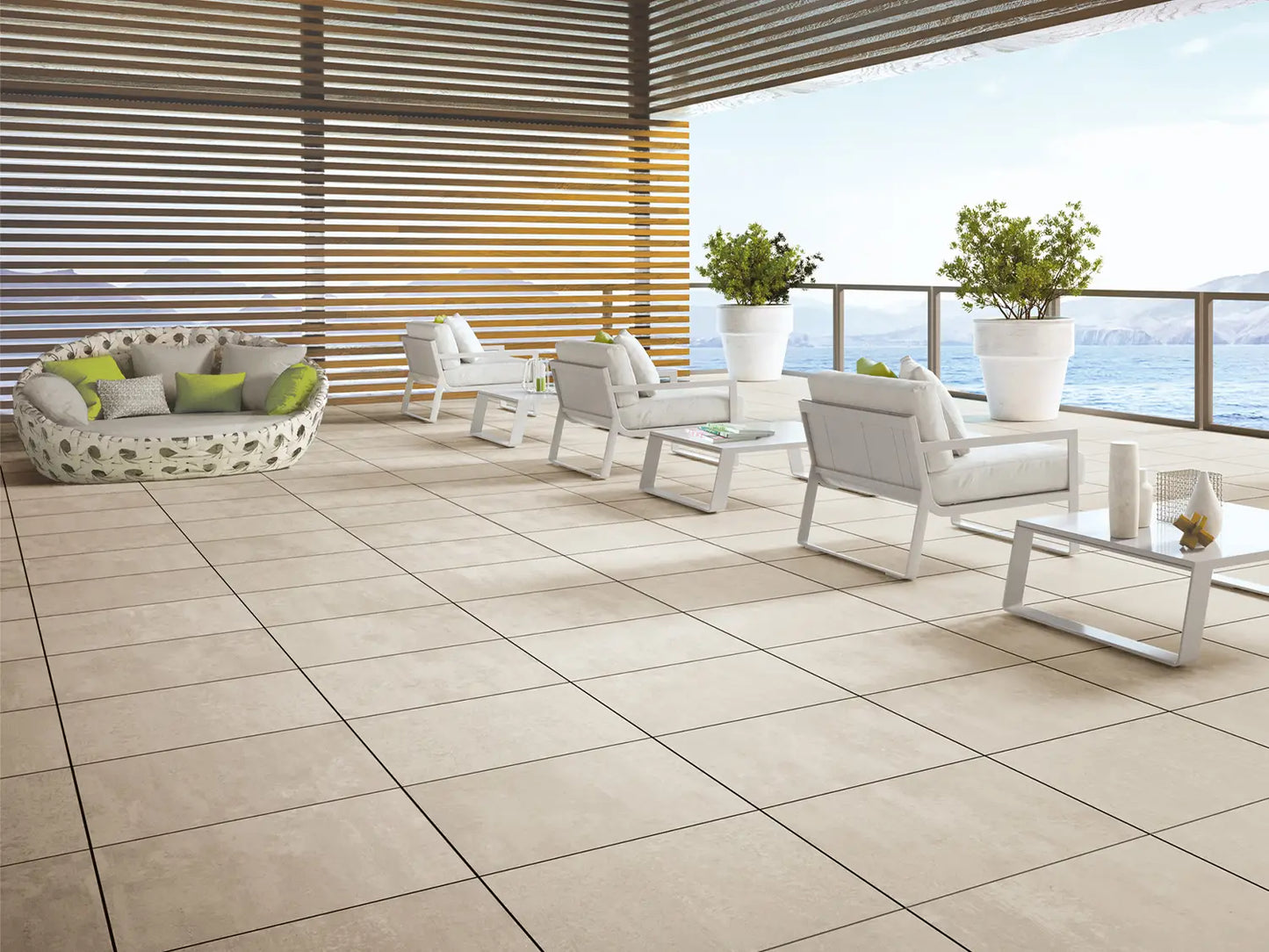 60x60 CeramicLine²-Terrassenplatten in beiger Natursteinoptik von Woehe & Heydemann verlegt auf einer modernen Dachterrasse mit Meerblick