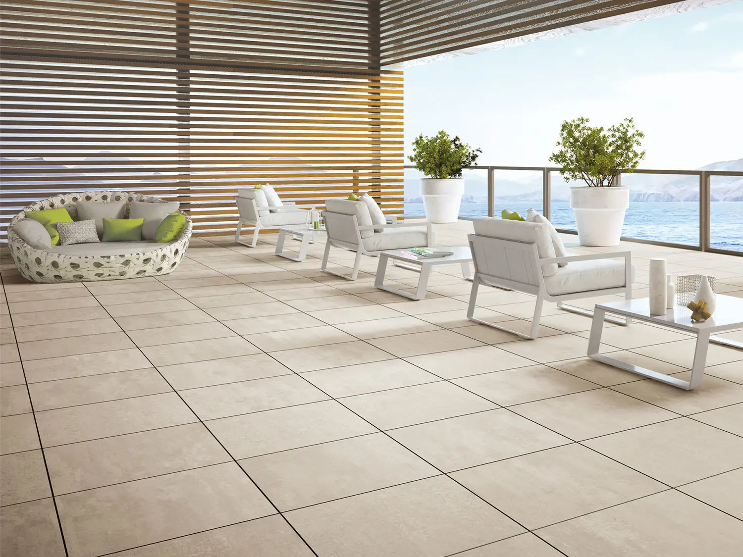 60x60 CeramicLine²-Terrassenplatten in beiger Natursteinoptik von Woehe & Heydemann verlegt auf einer modernen Dachterrasse mit Meerblick