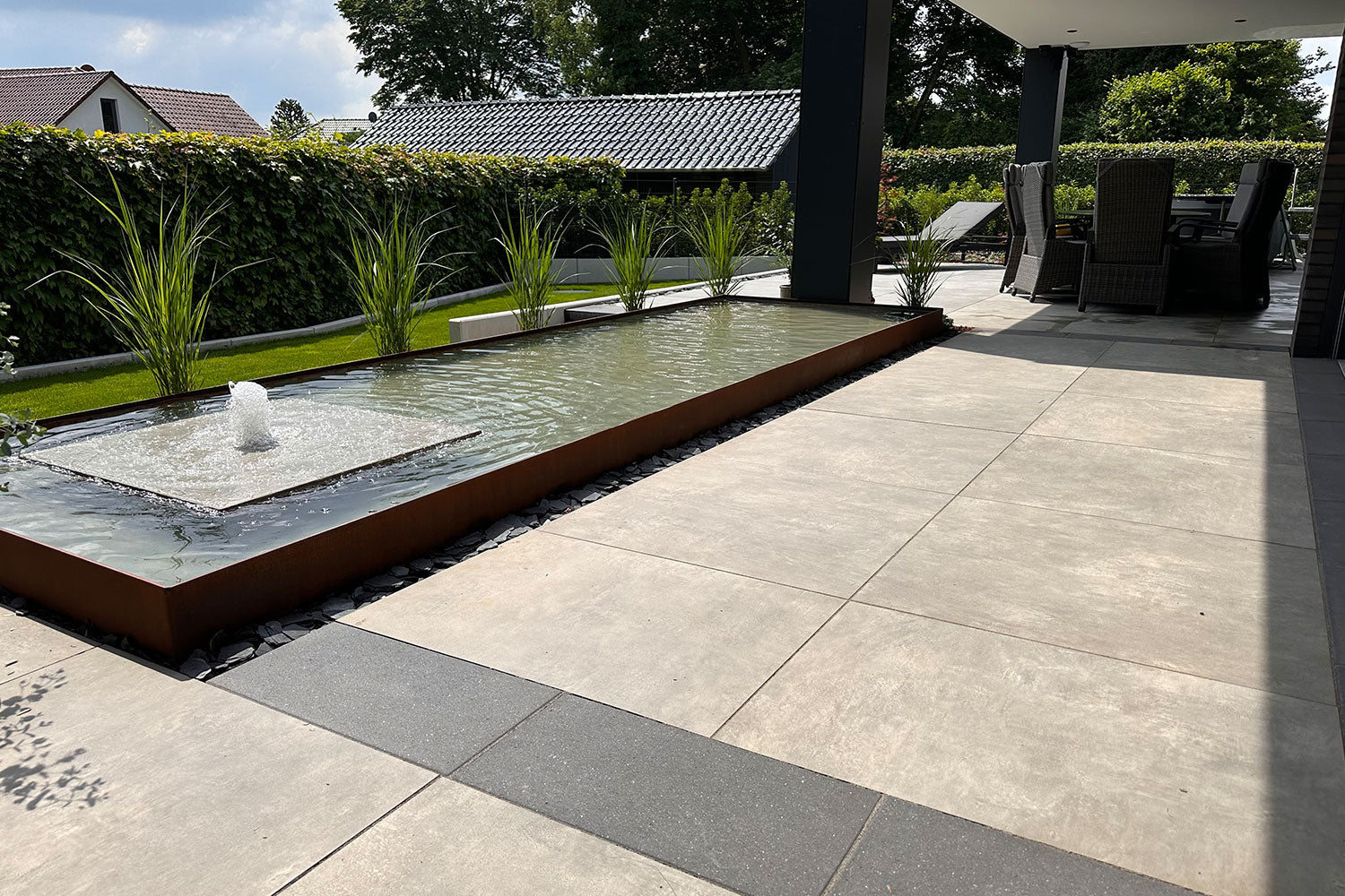 60x60 CeramicLine²-Terrassenplatten in beiger Betonoptik von Woehe & Heydemann verlegt auf einer modernen Terrasse im Garten