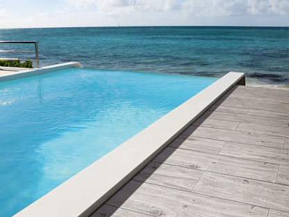 120x40 CeramicLine²-Terrassenplatten in grauer Holzoptik von Woehe & Heydemann verlegt auf einer modernen Terrasse mit Pool