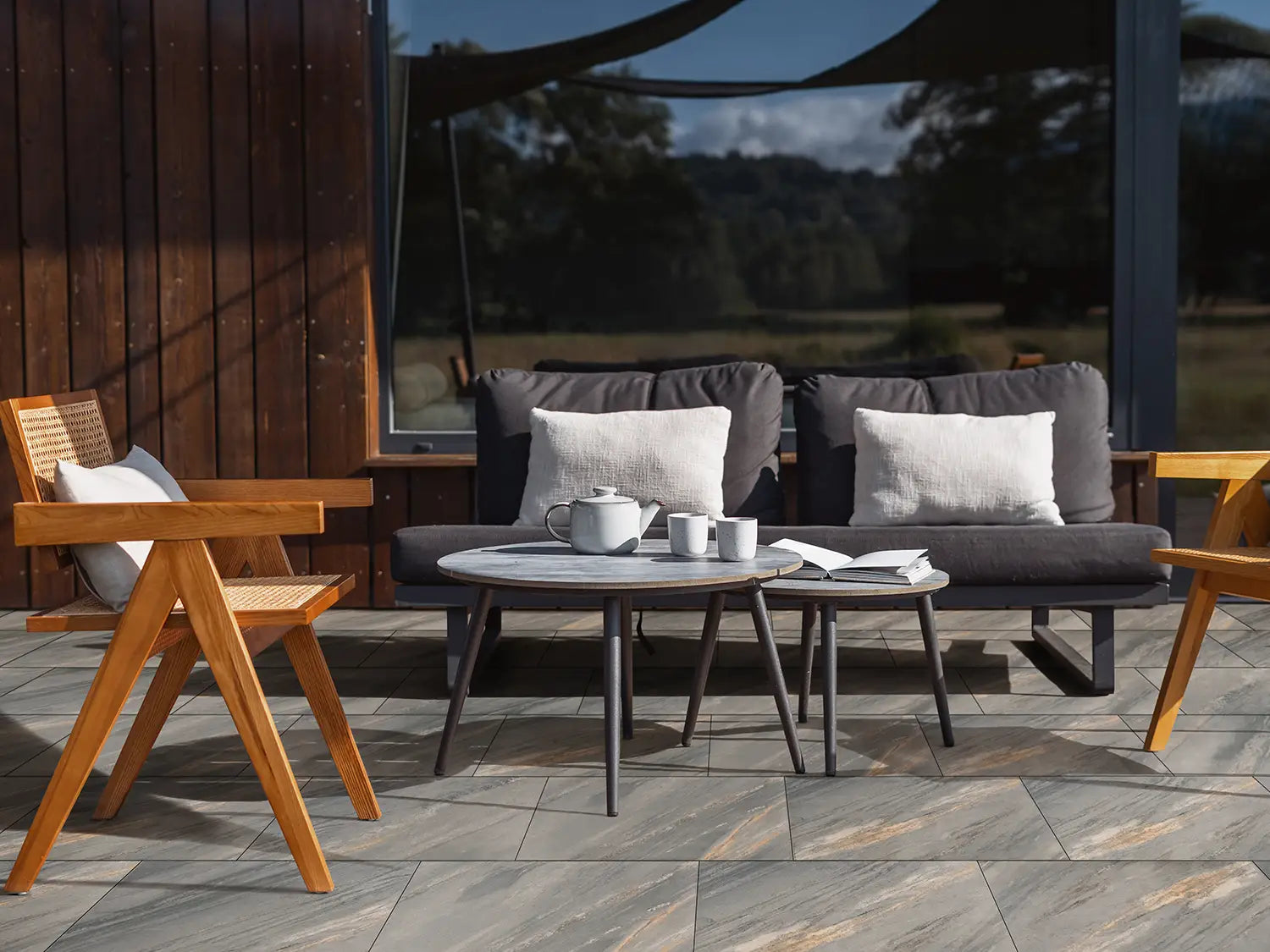 80x40 NanoLine-Terrassenplatten in grauer Natursteinoptik von Woehe & Heydemann verlegt auf einer modernen Terrasse mit Lounge