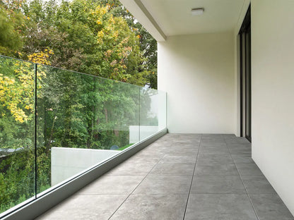 50x50 CreativeLine-Terrassenplatten in beiger Betonoptik von Woehe & Heydemann verlegt auf einem modernem Balkon mit Glasveranda