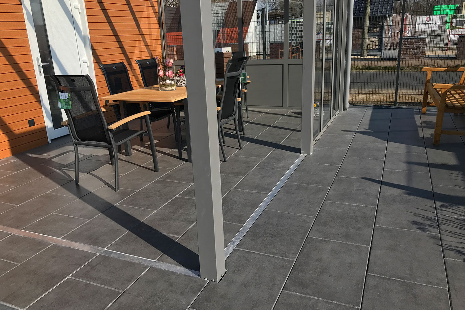 60x40 CreativeLine-Terrassenplatten in grauer Natursteinoptik von Woehe & Heydemann verlegt mit Terrasse im Wintergarten