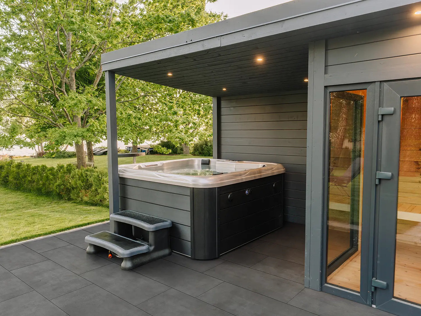 60x40 CreativeLine-Terrassenplatten in anthraziter Betonoptik von Woehe & Heydemann verlegt auf einer Terrasse mit Whirlpool und Sauna