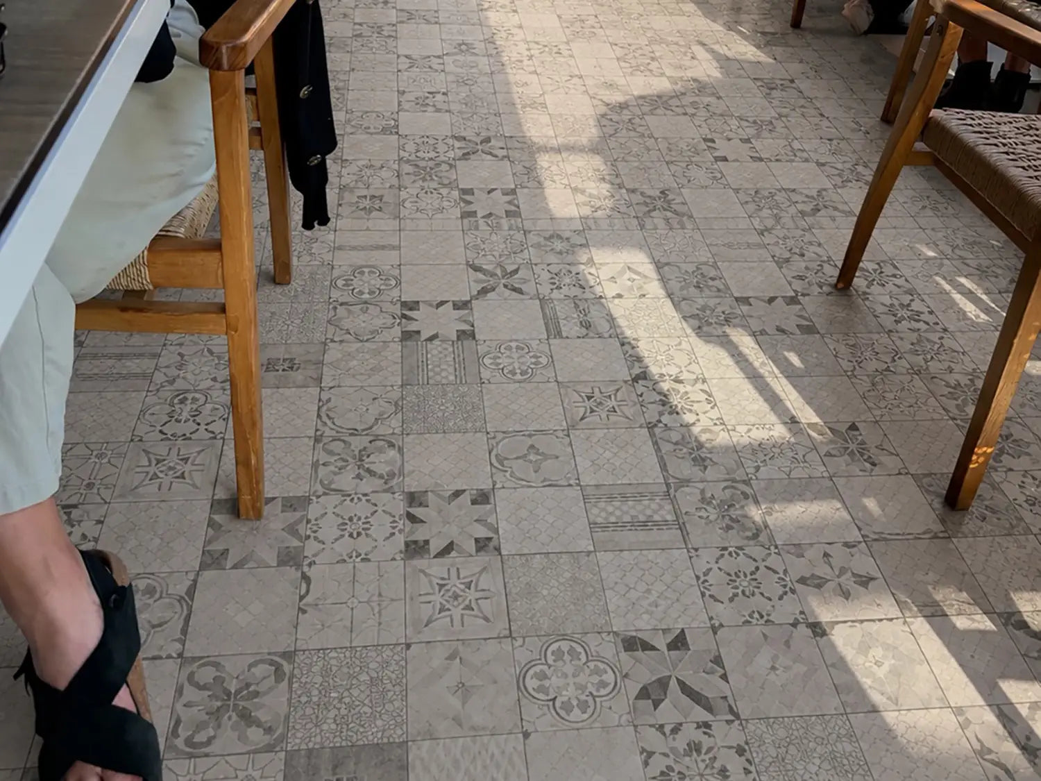 60x60 CreativeLine-Betonplatten in grauer Mosaik-Optik von Woehe & Heydemann verlegt auf einer modernen Terrasse mit einem Esstisch