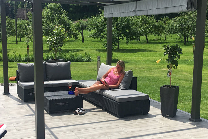 80x40 CreativeLine-Terrassenplatten in grauer Natursteinoptik von Woehe & Heydemann verlegt auf einer modernen Terrasse im Grünen mit Loungemöbeln