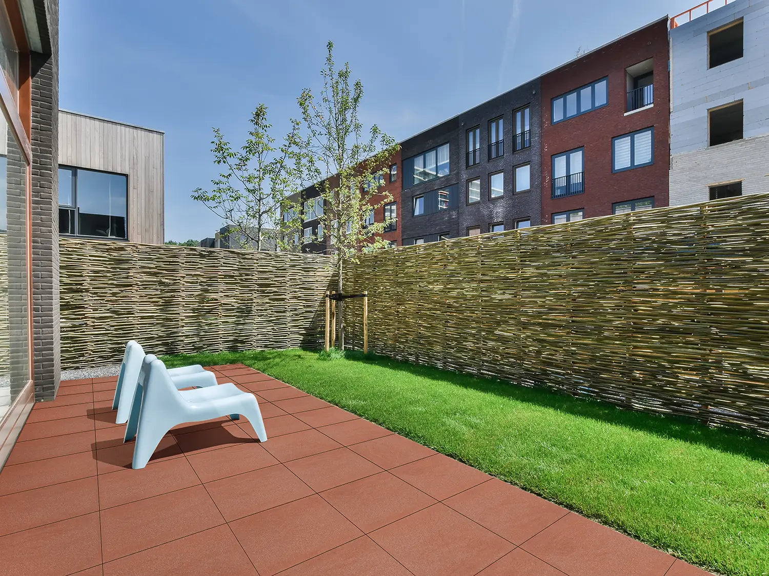 50x50 LuxoGran-Terrassenplatten in roter Natursteinoptik von Woehe & Heydemann verlegt auf einer modernen Terrasse 