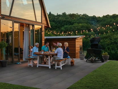 80x40 LuxoGran-Terrassenplatten in grauer Natursteinoptik von Woehe & Heydemann verlegt auf einer gemütlichen Terrasse mit Grill und Lichterkette
