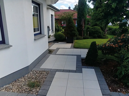 40x40 LuxoGran-Terrassenplatten in beiger Natursteinoptik von Woehe & Heydemann verlegt auf dem Weg zum Hauseingang