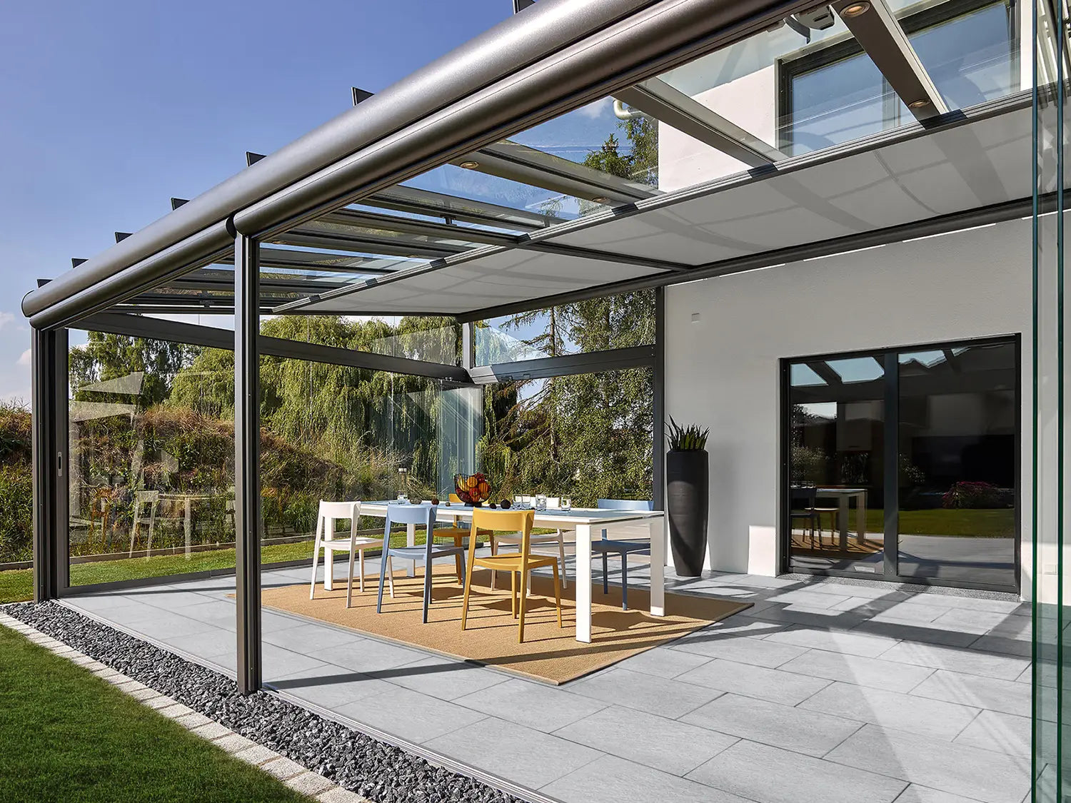 60x40 LuxoGran-Terrassenplatten in grauer Natursteinoptik von Woehe & Heydemann verlegt auf einer modernen Terrasse im Wintergarten