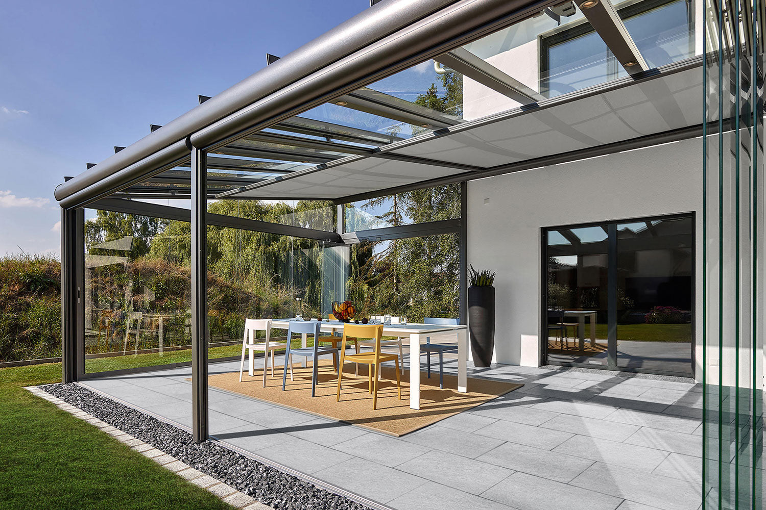 60x40 LuxoGran-Terrassenplatten in grauer Natursteinoptik von Woehe & Heydemann verlegt auf einer modernen Terrasse im Wintergarten