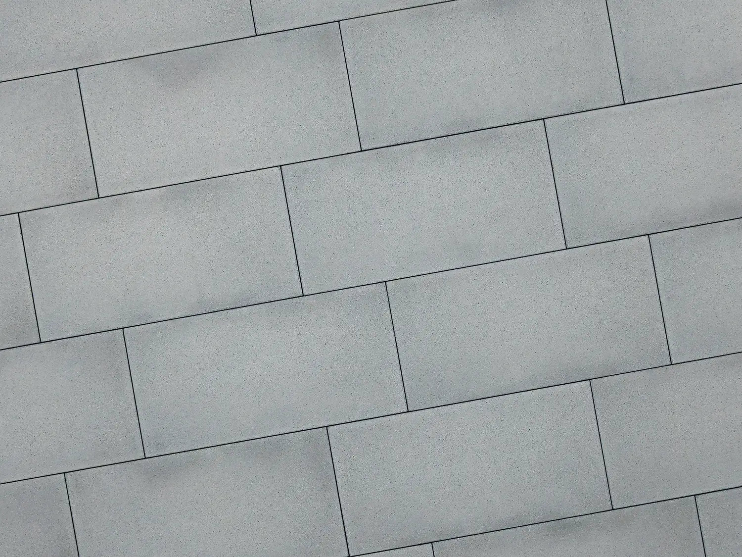 80x40 LuxoGran-Terrassenplatten in grauer Natursteinoptik von Woehe & Heydemann verlegt auf einer modernen Terrasse 