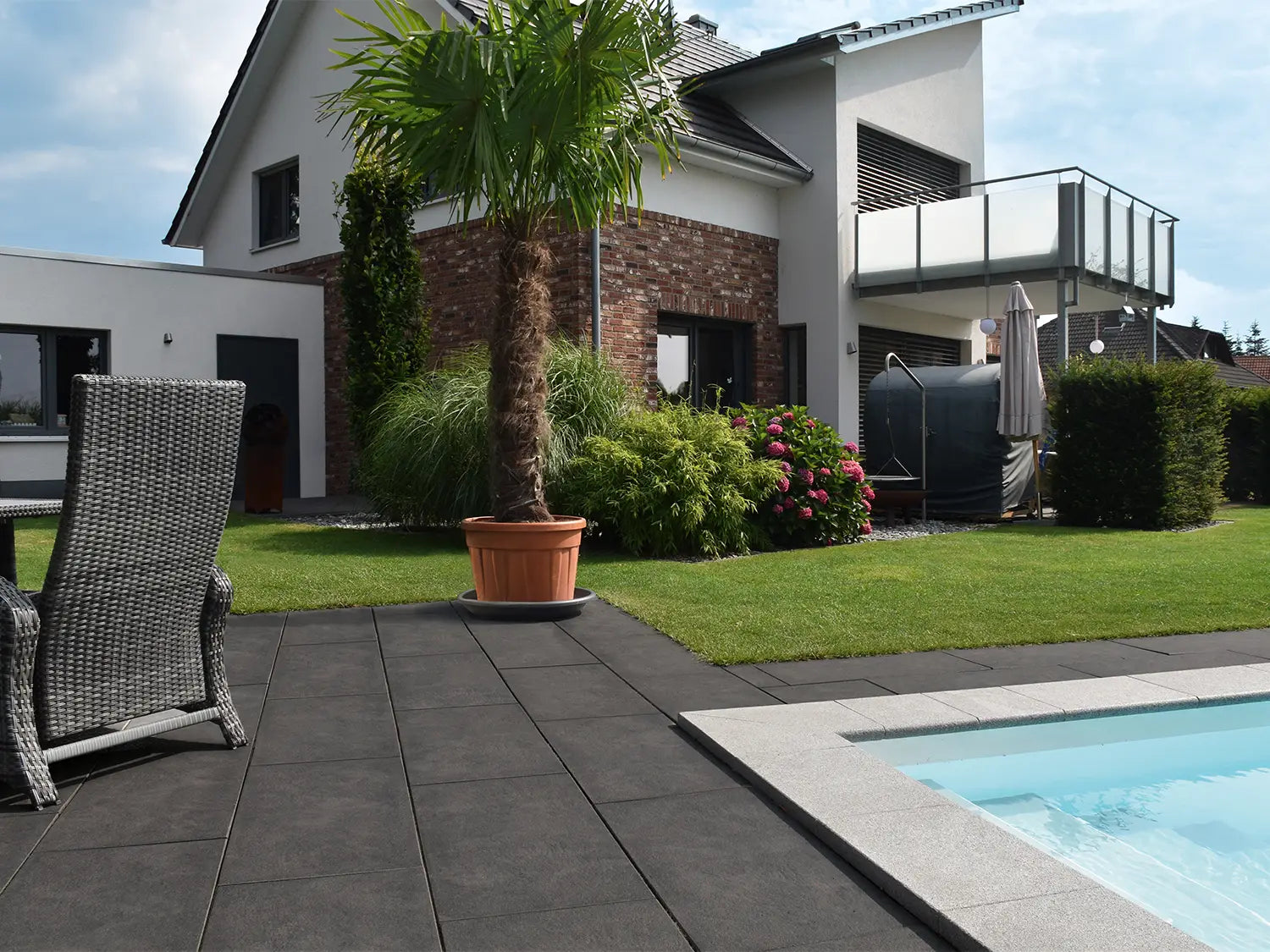 80x40 NanoLine-Terrassenplatten in grauer Natursteinoptik von Woehe & Heydemann verlegt auf einer modernen Terrasse 