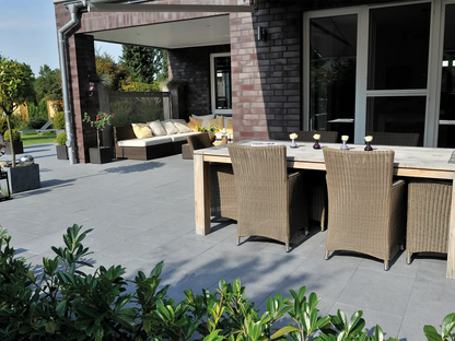 80x40 NanoLine-Terrassenplatten in grauer Natursteinoptik von Woehe & Heydemann verlegt auf einer modernen Terrasse mit Esstisch und Loungeecke