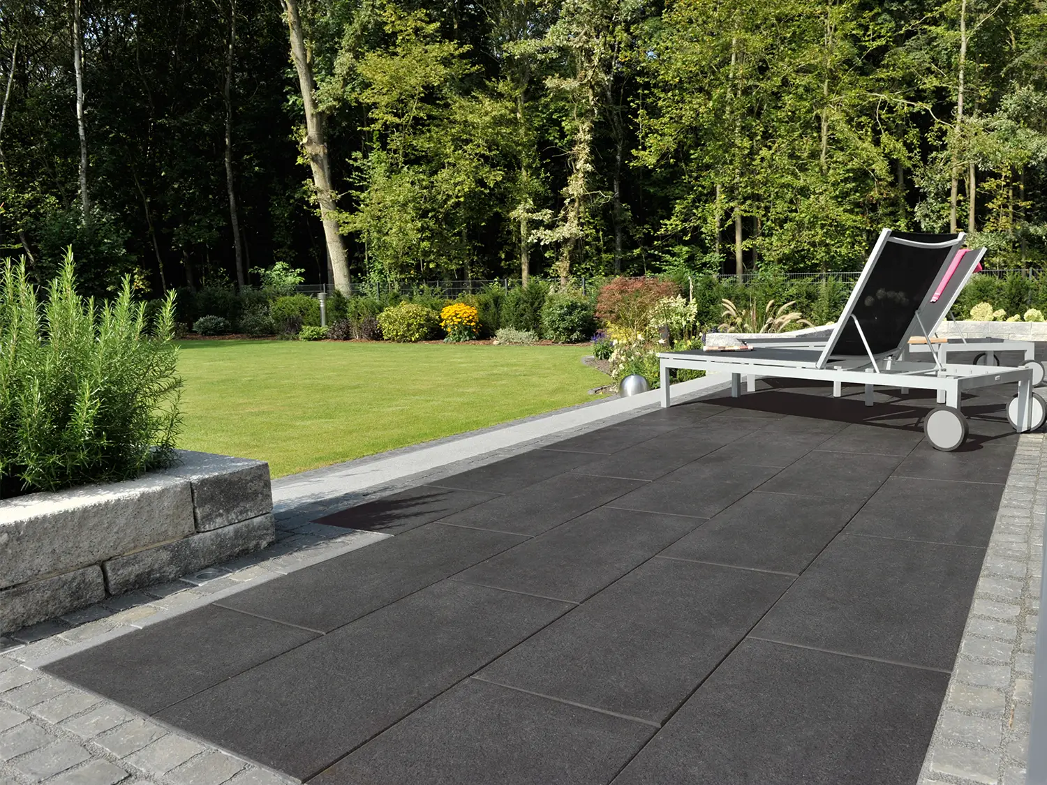 80x40 NanoLine-Terrassenplatten in grauer Natursteinoptik von Woehe & Heydemann verlegt auf einer modernen Terrasse mit Liegestühlen