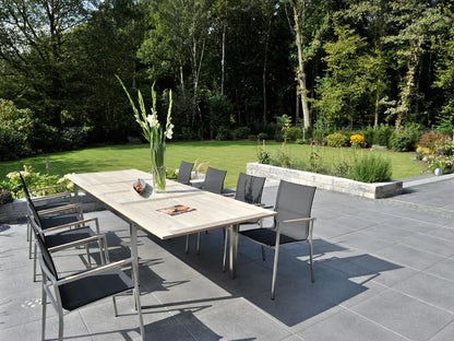 Verlegte PremiumLine-Platten in grau von Woehe & Heydemann in 60x60 – Naturstein-Optik im Garten langem Esstisch und einer harmonischen Linienführung 