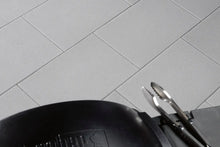 60x40 NanoLine-Terrassenplatten in grauer Natursteinoptik von Woehe & Heydemann verlegt auf einer modernen Terrasse mit Grill