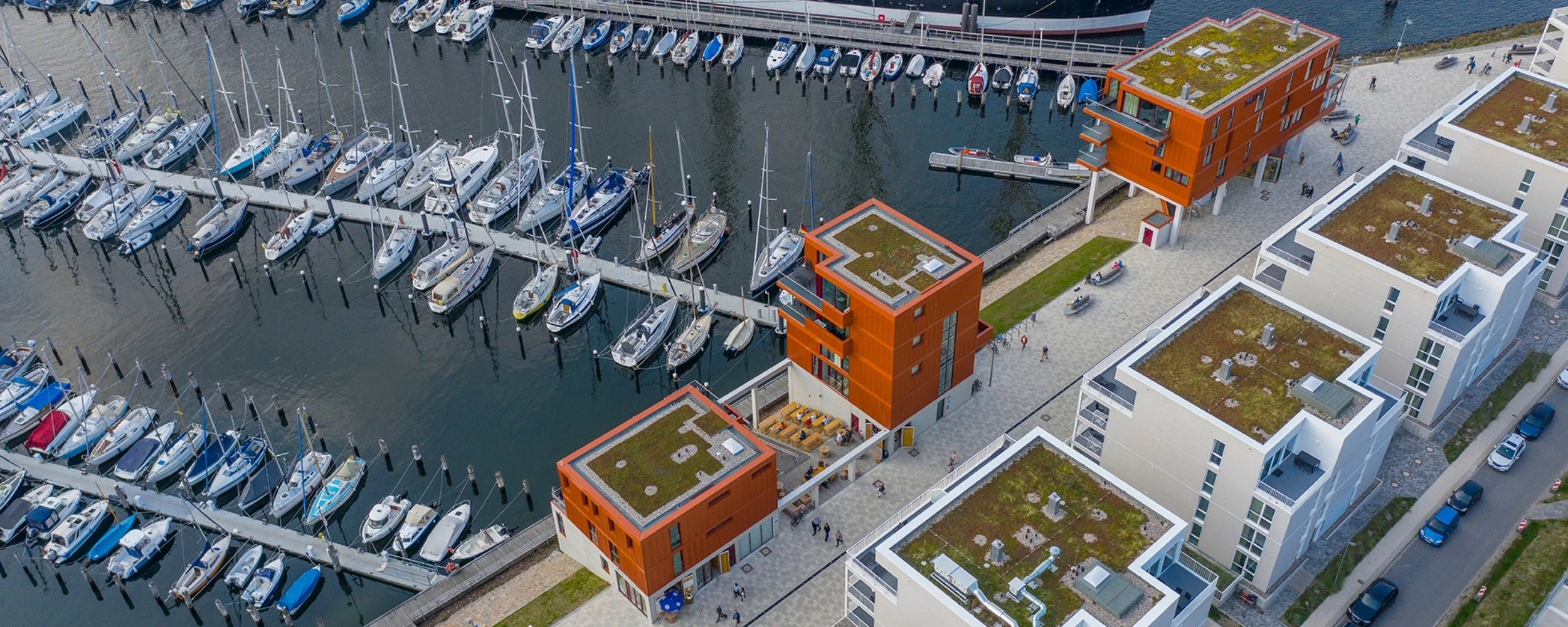 Banner Bild zur Landingpage "Stadtentwicklung und -planung für Außenbereiche im öffentlichem Raum", dass ein Projekt von Woehe & Heydemann mit einer Promenade und Hafen zeigt