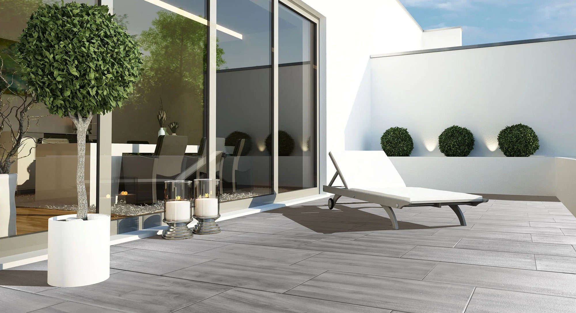 80x40 CreativeLine-Terrassenplatten in grauer Natursteinoptik von Woehe & Heydemann verlegt auf einer modernen Dachterrasse mit Liegestuhl