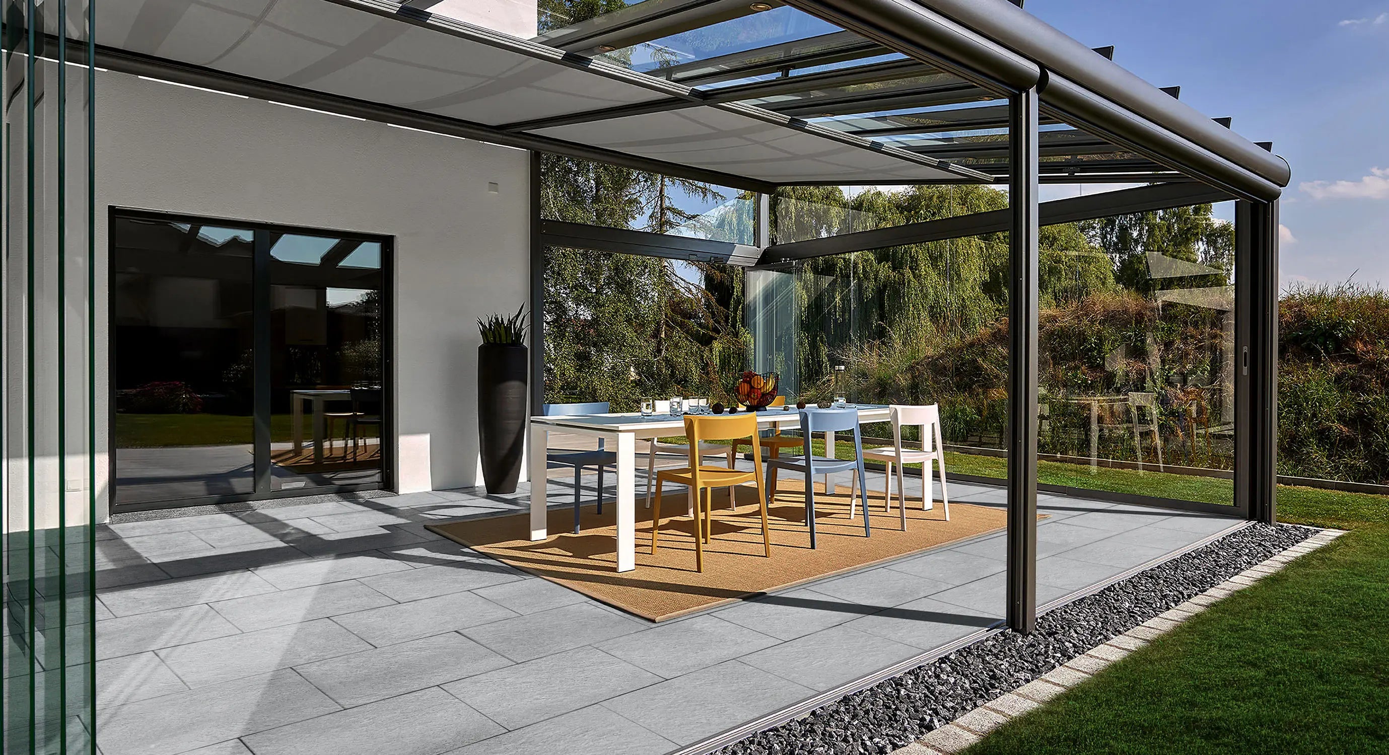 60x40 LuxoGran-Terrassenplatten in grauer Natursteinoptik von Woehe & Heydemann verlegt auf einer modernen Terrasse im Wintergarten