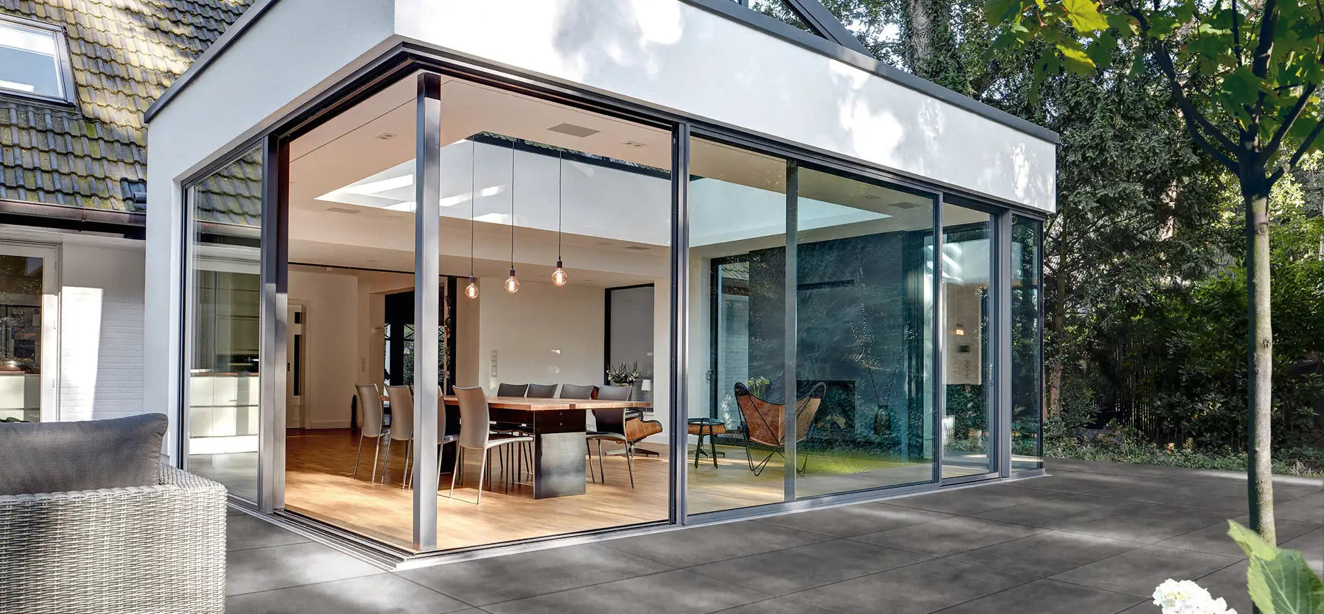 100x50 CreativeLine-Terrassenplatten in grauer Natursteinoptik von Woehe & Heydemann verlegt auf einer modernen Terrasse am Wintergarten