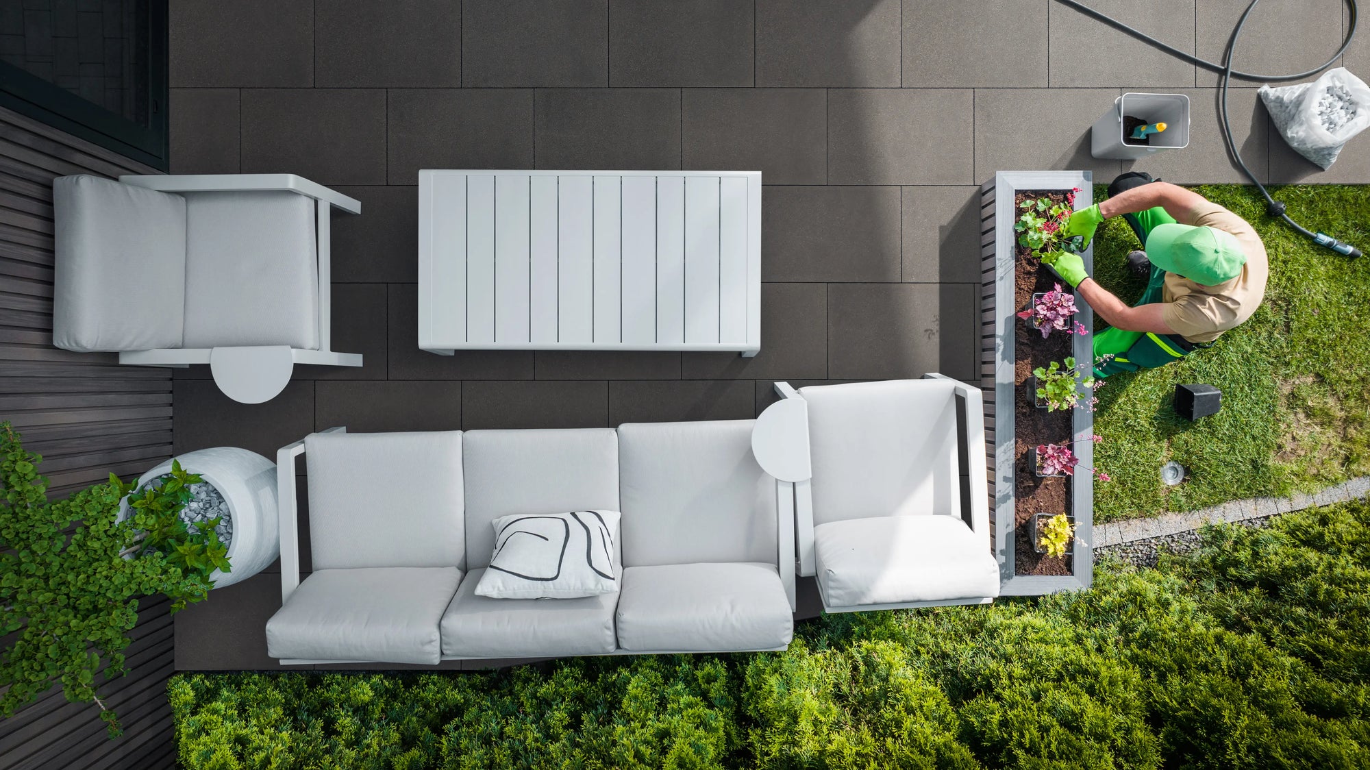 Garten- und Landschaftsbauer verlegt Woehe & Heydemann LuxoGran Terrassenplatten 71064 in grauer Natursteinoptik.