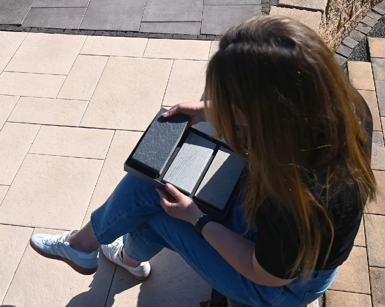 Person nimmt Terrassenplatten Handmuster aus Handmusterbox raus