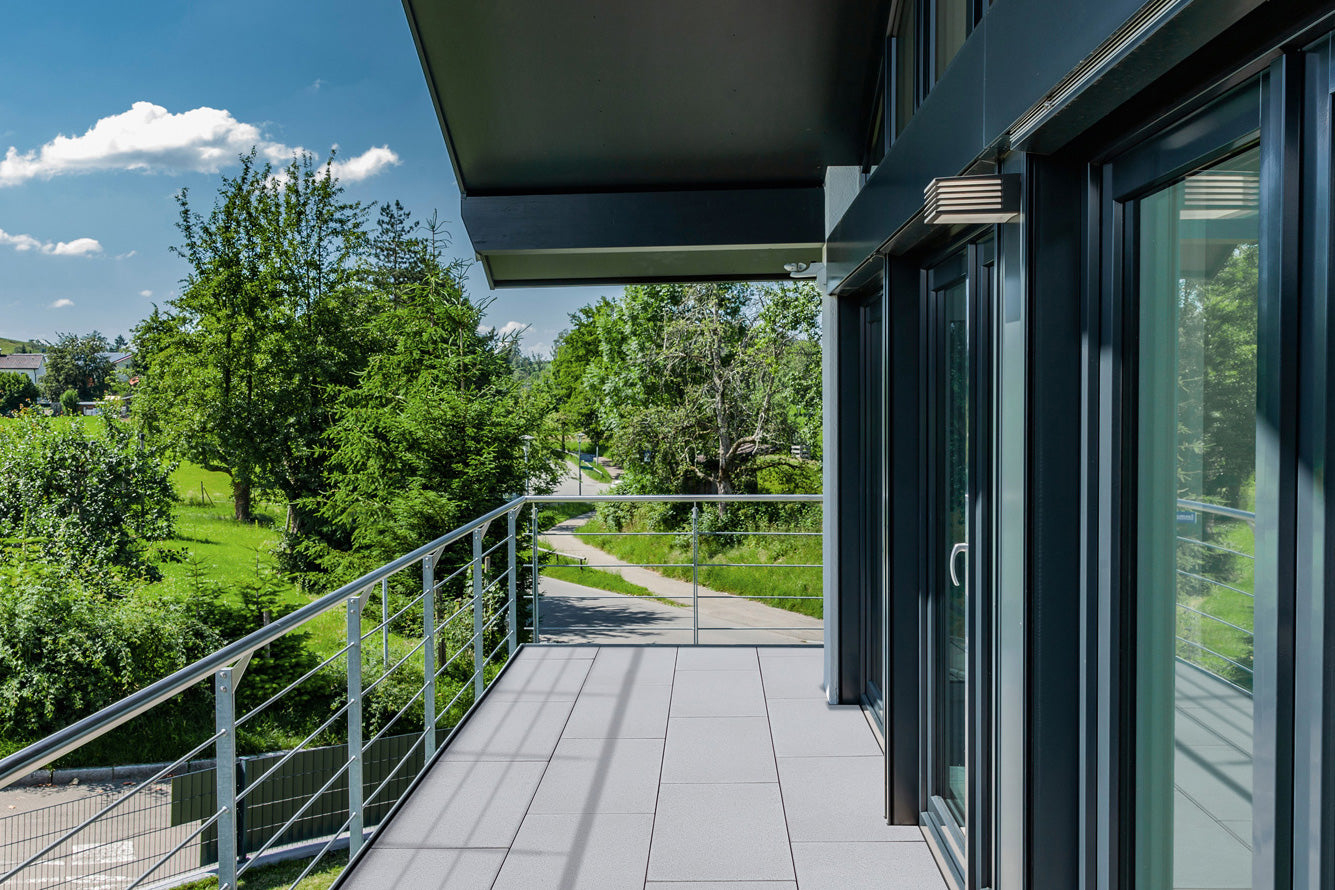 80x40 ZeroLine-Terrassenplatten in grauer Natursteinoptik von Woehe & Heydemann verlegt auf einer modernen Dachterrasse 