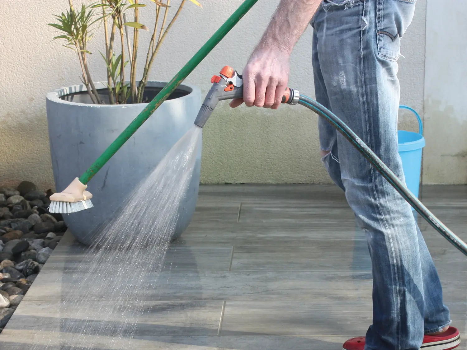 Woehe & Heydemann Terrassenplatten der Serie NanoLine aus Beton werden mit Besen gereinigt